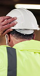 Back, engineer or man in building with helmet, manual labor safety regulations and injury prevention. Person, PPE or hard hat at construction site for protection, civil engineering or rule compliance