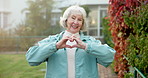 Senior, face and happy woman with heart hands in garden for retirement, love or outdoor romance. Portrait, elderly or female person with smile, like emoji or romantic gesture for passion or care