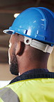 Construction, helmet and man on site with inspection, risk control and safety in building project. PPE, back or engineer with hardhat, uniform compliance or hazard prevention in industrial evaluation