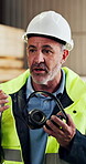 Carpenter, talking and man with ear muffs, conversation and safety briefing for team and compliance. Woodworking, supervisor and mature person with PPE, hearing protection and instructions in factory