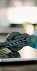 Closeup, empty and headset at call center with laptop, contact us and customer service for crm. Help desk, mic and online in office with pc, virtual assistance and telecom advisory for tech support