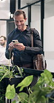 Phone, walking and businessman in office with texting, email or feedback on finance report. Tech, reading and mature financial manager on cellphone for update on investment proposal in workplace.