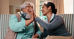 High five, book and nurse with old woman on sofa for crossword puzzle, support and celebration. Alzheimer prevention, strategy game and trivia solution with people in living room of home for answer