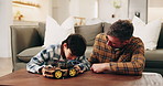Dad, child and building with toy car in home for assembling parts, bonding or fun activity together. Father, kid or helping son on electrical motor vehicle for junior engineering or learning in house