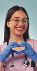 Medical, face and nurse with heart hands, support and patient care with friendly symbol. Happy, woman and doctor with positive emoji, healthcare encouragement or kindness shape on studio background.