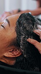 Cleaning, hands and shampoo with customer at hairdresser for change, hair maintenance or process. Hygiene, washing and water with women in hairdressing workplace for haircare or keratin treatment
