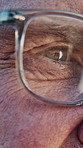 Optometry, closeup and elderly man with glasses for vision, eyesight and prescription lens. Thinking, ophthalmology and person with frames, spectacles and eye care for optical wellness or healthcare