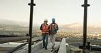 Teamwork, talking and walking with men on construction site for meeting or planning. Blueprint, building and tablet with architect people on worksite together for project management or update