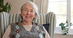 Happy, face and senior woman in home with laugh for positive attitude, good mood and relax. Retirement, portrait and elderly person in chair with smile, calm and peaceful for wellness, rest and break
