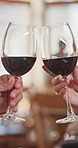 People, hands and red wine with cheers in restaurant for romantic dinner, date or fine dining. Glasses, man and woman with toast or love in diner for romance, celebration or anniversary together 