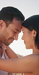 Happy, couple and forehead touch outdoor with love, sunshine and bonding together on summer holiday. Sun flare, people and dating with smile for romantic relationship, wellness and peace on vacation.
