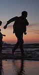 Couple, sunset and running in ocean with love, water splash and playful on romantic vacation. Man, woman and travel at beach with bonding, summer holiday or fun adventure on tropical coast in evening