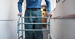 Senior, hands or hallway with walker in retirement apartment for mobility or movement in house. Elderly, patient or person walking with aid or help for assistance, balance or recovery in nursing home