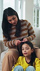 Mother, child and help with hair care on sofa, conversation and bonding together on weekend. Parent, girl and hairstyle in home for beauty routine with grooming, kid talking and family support