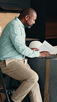 Laptop, paper and project management with black man in kitchen of home for renovation. Computer, documents and stepladder with mature architect in modern apartment for real estate development