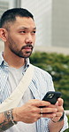 Phone, thinking and man in city with texting, chatting or research on web development project. Planning, technology and Asian software engineer with cellphone for email feedback on update in town.