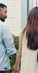Love, walking or couple in town with holding hands, romantic moment or bonding together on weekend trip. Trust, back or people with stroll, partner connection or outdoor date in caring relationship.