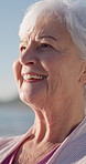 Thinking, smile and senior woman by beach on holiday with nostalgia, remember or memory of travel. Happy, mindfulness and elderly person in retirement by ocean with reflection on seaside vacation. 