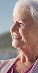 Thinking, happy and senior woman by beach on holiday with nostalgia, remember or memory of travel. Smile, mindfulness and elderly person in retirement by ocean with reflection on seaside vacation. 
