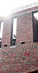 Empty, site and building outdoor for construction, remodeling and renovation project. Architecture, background and property structure for development progress with brick wall, scaffolding and masonry