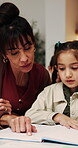 Mom, child and teaching with book in home for education, homework or tutoring daughter. Mother, reading or kid with study notebook or learning for homeschooling or childhood development in house