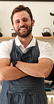 Face, man and waiter with arms crossed in cafe, entrepreneur and about us for hospitality. Portrait, male person and business owner at coffee shop with smile, positive attitude and catering industry