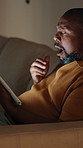 Tired, night and black man with tablet in home for fatigue, online streaming or browsing on sofa. Exhausted, male person or yawn with technology in late evening for subscription or research in house