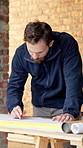 Man, engineer and drawing at site with document, blueprint and review design for construction. Male person, writing and planning with paperwork, sketch building and change floor plan for architecture