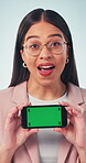 Presentation, face and businesswoman with phone, green screen or recommendation for social media app. Blue background, mock up space and happy person with mobile display, promotion or offer in studio