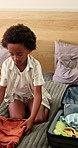 Packing, home and child with suitcase for travel, vacation and prepare for holiday. Family, bedroom and kid with clothes, outfit and excited with luggage for adventure, getaway and weekend trip