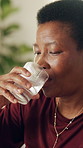 Black woman, relax and water at house with medicine, supplements and prescription for recovery. Mature person, drinking and beverage in home with pills, omega 3 and iron drugs for wellness benefits