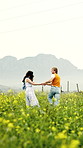 Holiday, spin or couple in countryside with holding hands, bonding or happy moment on trip. Laugh, space or people in field with fun, romantic relationship or playful connection on outdoor getaway.
