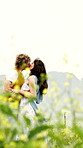 Holiday, kiss or couple in field with fun, bonding together or happy moment on outdoor trip. Laugh, space or people with loving hug, romantic relationship or playful connection on countryside getaway