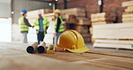Helmet, carpentry and document for safety in warehouse with engineer group in meeting for planning deal. People, blueprint and ppe with team for woodwork, manufacturing or collaboration in factory