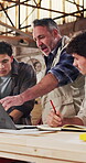Workshop, team and carpentry manager with laptop for project briefing, review CAD design or training. Tech, men or supervisor with production meeting for joinery workflow, task delegation or planning