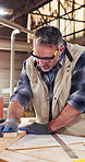 Carpenter, man and sanding wood in workshop for craft, manufacturing preparation and smooth surface. Sandpaper, woodwork and mature person with plank for furniture production process with tools