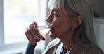Senior, woman and drinking with water in retirement home for hydration, cure or vitamins. Thoughtful, elderly or female person with mineral liquid for sustainability, medication or treatment in house