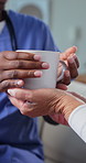 Hands, drink and caregiver with senior woman in home for assisted living, help and support. Retirement, giving and nurse with elderly person for service, aid and kindness with tea for wellness
