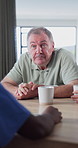 Senior, man and discussion with nurse in house for healthcare plan, advice or assisted living. Elderly, male person or talking with caregiver for medical help, conversation or chat in nursing home