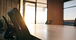 Conference, room and empty office with chairs in corporate building for meeting preparation. Space, equipment or boardroom table with lens flare, windows or sunshine for work seminar or interior