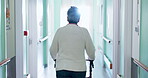 Walker, healthcare and back of old woman in hospital for rehabilitation, checkup or support. Medical appointment, osteoporosis and walking with senior person with a disability in clinic for recovery