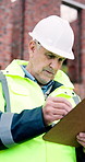 Man, engineer and clipboard at site for construction, survey and inspection report for architecture. Mature person, reading and checklist for safety protocol, compliance form and building development