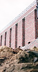 Construction, brick wall or empty site for building progress, excavation phase or renovation. Low angle, rubble or masonry structure on jobsite for property expansion, framework or remodeling project