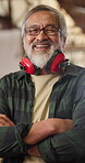 Arms crossed, face and smile of man in carpentry warehouse for management of manufacturing plant. Earmuffs, industry and production with mature carpenter in woodwork factory for professional joinery