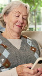 Happy, phone and relax with old woman on sofa in home living room for social media browsing. App, smile and text message with senior person in apartment for mobile communication or retirement