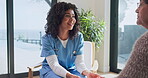 Holding hands, nurse and speaking with old woman on sofa in retirement home for assisted living. Checkup, healthcare and visit with caregiver talking to senior patient in apartment for service