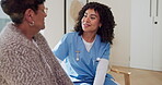 Healthcare, nurse and talking with senior woman in living room of retirement home for support. Communication, smile and visit with happy caregiver speaking to old person in apartment for service