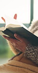Bible, reading and religion with hands of woman in living room of home for belief or spiritual study. Book, faith and learning with Christian person in apartment for holy gospel, hope or trust