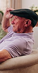 Thinking, relax and senior man on sofa in home with reflection, remember or memory in living room. Planning, hat and elderly person in retirement with nostalgia, ideas or decision in apartment.