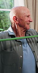 Physio, stretching and senior man with resistance band for health, shoulder rehabilitation or care. Retirement, elderly person or consultation in office with joint mobility or happy for progress